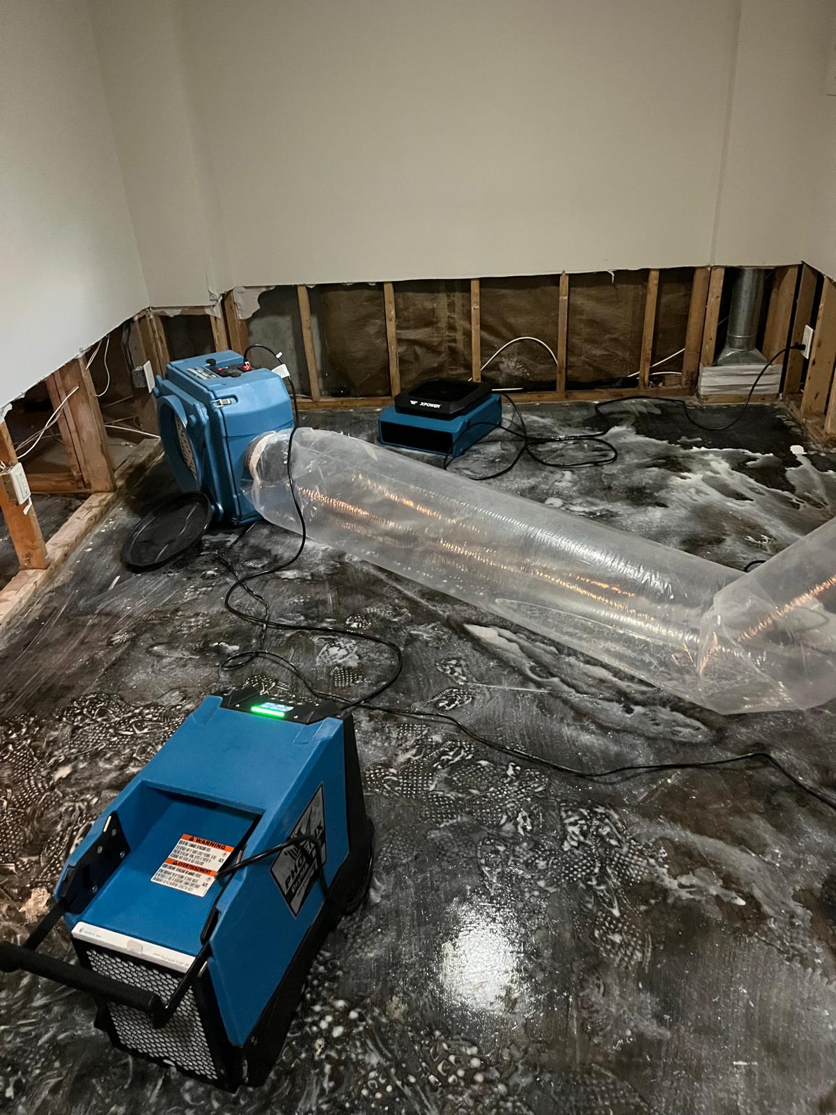 Dehumidifier, air scrubber and ducting in a wet basement after a flood
